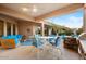 Outdoor patio area featuring blue cushioned seating, a ceiling fan, and an outdoor kitchen area at 9160 E Wethersfield Rd, Scottsdale, AZ 85260