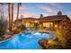 Backyard pool with palm trees, desert landscaping and view to interior seating at 9160 E Wethersfield Rd, Scottsdale, AZ 85260