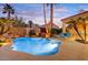 Sparkling pool with stone accents surrounded by palm trees and desert landscaping at 9160 E Wethersfield Rd, Scottsdale, AZ 85260