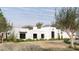 Modern home exterior featuring stucco siding, dark framed windows, desert landscaping and mature trees at 9611 E Clinton St, Scottsdale, AZ 85260