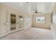 Bright living room features glass french doors, multiple windows, and a ceiling fan at 10001 W Deanita Ln, Sun City, AZ 85351