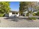 Expansive backyard featuring mature trees and a low-maintenance gravel landscape at 10013 W Augusta Dr, Sun City, AZ 85351