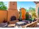 Picturesque outdoor fireplace and seating with beautiful plants, adding charm to the courtyard at 10597 E Rising Sun Dr, Scottsdale, AZ 85262