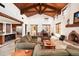 Expansive living room with vaulted ceilings, exposed beams, and a cozy fireplace at 10597 E Rising Sun Dr, Scottsdale, AZ 85262