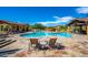 Resort-style pool with ample seating surrounded by lush landscaping and desert architecture at 10597 E Rising Sun Dr, Scottsdale, AZ 85262