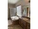 Bright bathroom featuring a soaking tub with glass block surround and a spacious vanity at 11415 E Four Peaks Rd, Scottsdale, AZ 85262