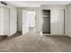 Bedroom with light carpet, closet with sliding doors, and a doorway to another room in the house at 11609 N 30Th Ln, Phoenix, AZ 85029