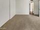 Bedroom featuring neutral carpet, white walls, and an open doorway for easy access to other rooms at 11609 N 30Th Ln, Phoenix, AZ 85029