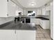The kitchen features white cabinets, a black cooktop and black dishwasher, and a double basin sink at 11609 N 30Th Ln, Phoenix, AZ 85029