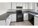 Clean kitchen featuring sleek black appliances, white cabinetry, and countertops at 11609 N 30Th Ln, Phoenix, AZ 85029