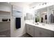 Modern bathroom with double vanity, sleek countertops, and a large mirror reflecting the bedroom at 14598 W Wood Dr, Surprise, AZ 85379