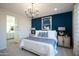 Well-lit bedroom with blue accent wall, soft carpet, and a view into a well-lit bathroom at 14598 W Wood Dr, Surprise, AZ 85379