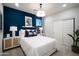 Bright bedroom featuring a stylish accent wall, modern lighting, and a cozy white bed at 14598 W Wood Dr, Surprise, AZ 85379
