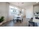 Bright dining area with a white table, grey chairs and a modern light fixture at 14598 W Wood Dr, Surprise, AZ 85379