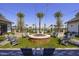 Community firepit with Adirondack chairs, palm trees, string lights, and views of pool at 14598 W Wood Dr, Surprise, AZ 85379