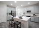 Gorgeous kitchen with stainless steel refrigerator, grey cabinets, and large island with breakfast bar at 14598 W Wood Dr, Surprise, AZ 85379