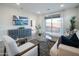 Open-concept living room with a view to the bedroom, featuring modern furnishings and stylish accents at 14598 W Wood Dr, Surprise, AZ 85379