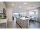 Open-concept living space with grey cabinets, island seating, and grey wood-look floors at 14598 W Wood Dr, Surprise, AZ 85379