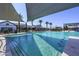 Community pool with in-water seating, umbrellas, and shade sails at 14598 W Wood Dr, Surprise, AZ 85379