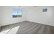 Bright bedroom with neutral carpet, white walls, and a large window offering ample natural light at 14787 W El Cortez Pl, Surprise, AZ 85387