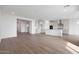 Bright, open-concept living space with wood-look tile floors that flows into the gourmet kitchen at 14787 W El Cortez Pl, Surprise, AZ 85387