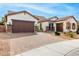 Suburban home showcasing brick driveway, three-car garage, and desert landscaping with a blue sky background at 15997 W Vernon Ave, Goodyear, AZ 85395