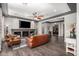 Inviting living room with a stone fireplace, dark-stained wood floors, and stylish ceiling fan at 15997 W Vernon Ave, Goodyear, AZ 85395