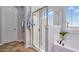 Bright bathroom with a glass shower, soaking tub, and tile floors, with shuttered window at 1644 N Lynch --, Mesa, AZ 85207