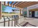 An outdoor kitchen featuring stainless steel grill and sink with a tile countertop under a wood pergola on a brick paver patio at 1644 N Lynch --, Mesa, AZ 85207