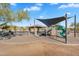 Community playground with a shade covering, swings, slides, and climbing features at 1644 N Lynch --, Mesa, AZ 85207