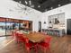 Spacious dining room with a large wooden table, red chairs, and modern lighting fixture at 17687 W Amber Dr, Goodyear, AZ 85338