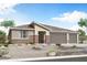 Charming single-story home showcasing desert landscaping, a brick facade, and an attached three-car garage at 18441 W Mohave St, Goodyear, AZ 85338