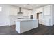 A gorgeous kitchen featuring white cabinets, a center island, stainless steel appliances and a white backsplash at 18447 W Mohave St, Goodyear, AZ 85338