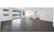 Open concept living room adjacent to a kitchen featuring white cabinets and stainless steel appliances at 18447 W Mohave St, Goodyear, AZ 85338