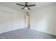 Bedroom features gray carpet, ceiling fan, and a closet with sliding doors at 1915 W Nopal Cir, Mesa, AZ 85202