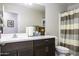 Bathroom featuring a long vanity with dark wood cabinets and a shower with striped curtains at 1973 N Lewis Pl, Casa Grande, AZ 85122