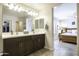 Bright bathroom featuring double sinks, sleek countertops, and a view into the bedroom at 1973 N Lewis Pl, Casa Grande, AZ 85122