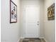Hallway view showcasing a white front door with decorative wall hangings and wood-look flooring at 1973 N Lewis Pl, Casa Grande, AZ 85122