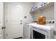 Clean laundry room with washer and dryer, storage shelf, and white door at 1973 N Lewis Pl, Casa Grande, AZ 85122