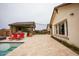 Home's backyard featuring an outdoor kitchen, covered patio, pool, lounging chairs, and stone pavers at 19777 E Ivy Ln, Queen Creek, AZ 85142