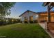 Backyard boasts grassy lawn, landscaped beds and string lights for evening enjoyment at 19777 E Ivy Ln, Queen Creek, AZ 85142