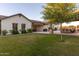 Spacious backyard with lush grass, mature trees, and a covered outdoor kitchen and dining area, perfect for entertaining guests at 19777 E Ivy Ln, Queen Creek, AZ 85142