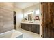 Spacious bathroom features a large vanity, a walk in closet and natural light at 19777 E Ivy Ln, Queen Creek, AZ 85142