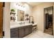 Bright bathroom boasts dark cabinets, white countertops, shelves, a makeup table and a walk in closet at 19777 E Ivy Ln, Queen Creek, AZ 85142