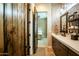 Stylish bathroom with tiled walls, a vanity, and a connecting doorway to a bedroom at 19777 E Ivy Ln, Queen Creek, AZ 85142