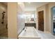 Light and airy bathroom with soaking tub, a walk in shower and dark cabinets at 19777 E Ivy Ln, Queen Creek, AZ 85142