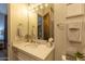 Bright bathroom with white vanity, large mirror and decorative towel racks at 19777 E Ivy Ln, Queen Creek, AZ 85142