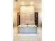 Modern bathtub in a neutral toned bathroom with a light tile backsplash at 19777 E Ivy Ln, Queen Creek, AZ 85142