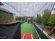 Exterior shot of a private batting cage with synthetic turf and safety netting in a well-maintained backyard at 19777 E Ivy Ln, Queen Creek, AZ 85142