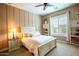 Cozy bedroom with a white bed frame, neutral walls, a ceiling fan and a bright window with shutters at 19777 E Ivy Ln, Queen Creek, AZ 85142